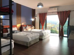 a bedroom with two bunk beds and a balcony at Baan Rai Phufah Resort Chiangrai in Ban Pa Ruak