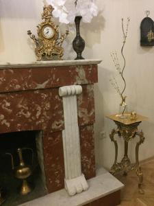 a fireplace with a clock on top of it at Brickwall Tbilisi-Tbilisi vibe in Tbilisi City