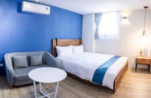 台南的住宿－沐藍輕旅 ，一间卧室配有一张床、一把椅子和一张桌子