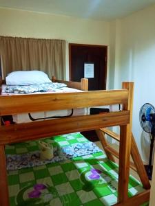 a bedroom with a bunk bed with a green floor at Aquing's Place in El Nido