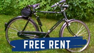 a bike parked in the grass with the words free rent at Family Guesthouse Chitwan in Maruwā Ghāt