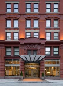 a large red brick building with glass doors at Kimpton Schofield Hotel, an IHG Hotel in Cleveland