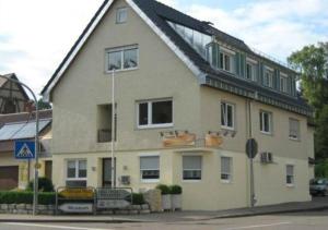 een groot huis met een dak op een straat bij Pension Wauri , Gästezimmer in Waldenbuch