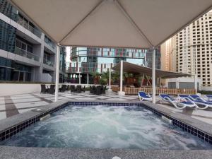a swimming pool with lounge chairs and a building at Icon Casa Living - Bay Central Tower JBR View in Dubai
