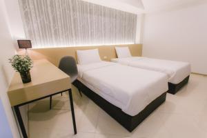 Postel nebo postele na pokoji v ubytování Royal Princess City Lamphun Hotel
