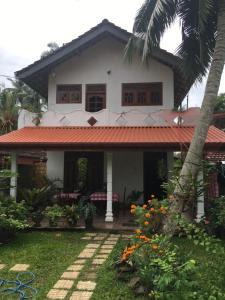 a house with a palm tree in front of it at Our House Hikkaduwa in Hikkaduwa