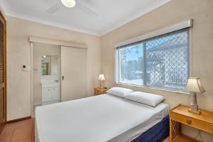 a bedroom with a white bed and a large window at Royal Palm Villas in Cairns +30 photos