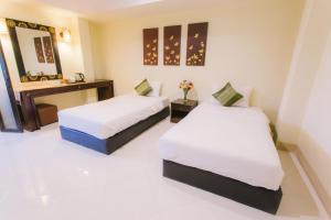 Postel nebo postele na pokoji v ubytování Royal Princess City Lamphun Hotel