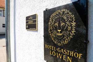 ein Schild mit einem Löwenkopf auf der Seite eines Gebäudes in der Unterkunft Hotel Loewen in Tübingen