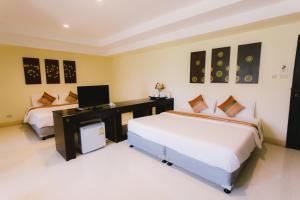 1 dormitorio con 2 camas y escritorio con ordenador en Royal Princess City Lamphun Hotel en Lamphun