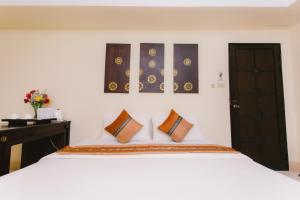 Postel nebo postele na pokoji v ubytování Royal Princess City Lamphun Hotel