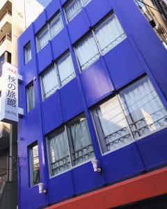 a blue building with windows on a city street at 秋の旅館 秋叶原 Tokyo Akihabara in Tokyo