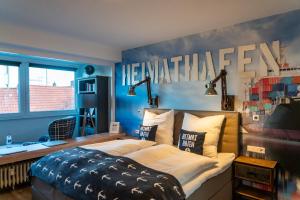 a bedroom with a bed with a welcome sign on the wall at Heimathafen in Cuxhaven +50 photos