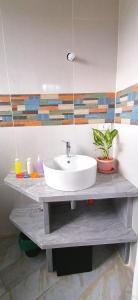een badkamer met een witte wastafel op een tafel bij Lonos Circle Private Garden in Romblon