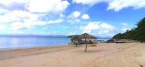 a beach with an umbrella and the water at Lonos Circle Private Garden in Romblon