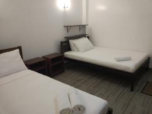 mały pokój z 2 łóżkami i 2 stołami w obiekcie CASA MIA INN w mieście Dauis