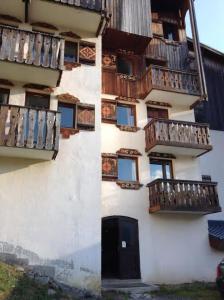 - un bâtiment avec des balcons en bois sur le côté dans l'établissement Les studios du chalet club Valfréjus, à Modane