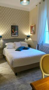 a bedroom with a large bed and a window at Hotel Relais Du Postillon in Antibes