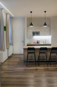 a kitchen with a counter and three stools in a room at Pacman Apartment in Budapest