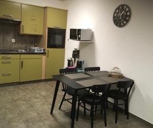 a kitchen with a table and chairs in a room at Le Président 2 in Sierre
