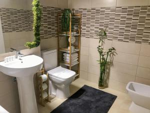 a bathroom with a white toilet and a sink at Condmari Residential Apartament in Braşov +32 photos