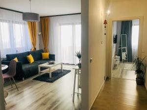 salon z niebieską kanapą i stołem w obiekcie Condmari Residential Apartament w Braszowie