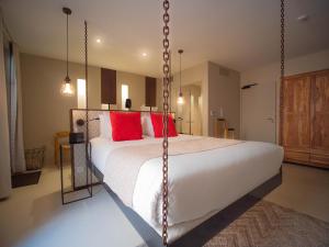 a bedroom with a large white bed with red pillows at Hotel Pont Levis - Franck Putelat in Carcassonne