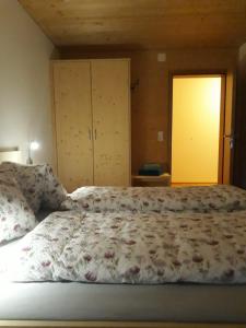 um quarto com uma cama com um edredão floral em Ferienwohnung Greber Regina em Bezau