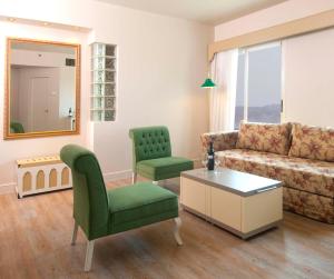 Herods Palace Hotels & Spa Eilat a Premium collection by Fattal Hotels في إيلات: غرفة معيشة مع أريكة وكرسي
