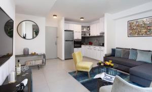 a living room with a couch and a kitchen at Beautiful 2BDR close to Bialik Place by HolyGuest in Tel Aviv