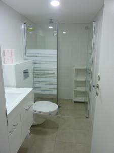 y baño blanco con aseo y ducha. en Allenby2 B&B en Jerusalem