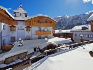 ein Gebäude im Schnee mit Bergen im Hintergrund in der Unterkunft Alphotel Taller Wellness & Sport in Folgarida