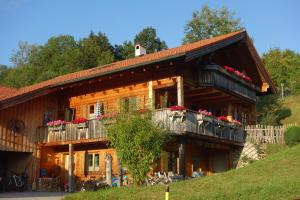 ein Holzhaus mit Balkonen und Blumen darauf in der Unterkunft Ferienwohnungen Bernie Schmid in Sonthofen