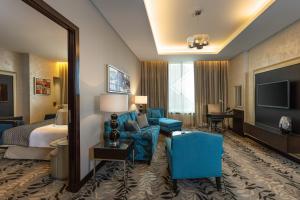 een hotelkamer met een bed, een bank en een televisie bij Crowne Plaza Riyadh - RDC Hotel & Convention, an IHG Hotel in Riyad