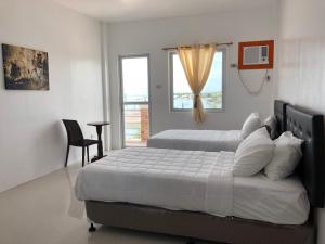a bedroom with two beds and a window at Arriyus Apartelle in Maya