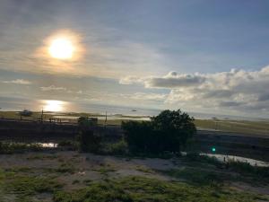 um pôr-do-sol sobre uma ponte com o sol no céu em Arriyus Apartelle em Maya
