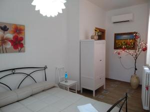 a white bedroom with a bed and a white cabinet at Trulli del boschetto in Putignano