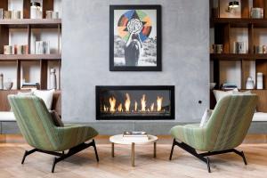 a living room with two chairs and a fireplace at Kimpton Rowan Palm Springs Hotel, an IHG Hotel in Palm Springs