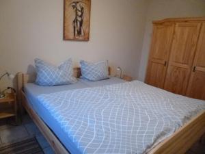 a bedroom with a large bed with blue pillows at Ferienwohnung Kirchblick in Heyweiler