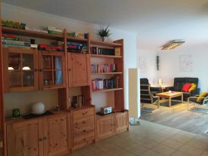 een woonkamer met een grote houten boekenplank bij Ferienhaus No.10 in Hemmoor