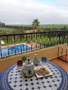 - une table avec une assiette de biscuits sur le balcon dans l'établissement Riad TANJIL, à Casablanca