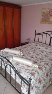 een slaapkamer met een bed met een bloemendeken bij Casa vacanze in Casarano