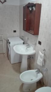 een badkamer met een wastafel, een toilet en een spiegel bij Casa vacanze in Casarano