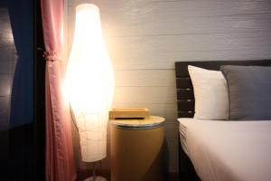 a lamp sitting next to a bed in a room at Marina hut guest house in Ko Lanta