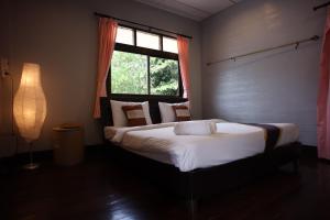 a bedroom with a large bed with a window at Marina hut guest house in Ko Lanta