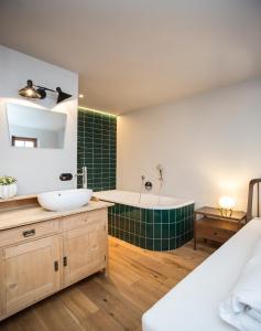a bathroom with a tub and a sink at HOLZGAUER HAUS in Warth am Arlberg +35 photos