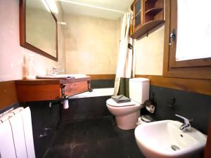 a bathroom with a white toilet and a sink at Isards, Atico rustico con chimenea en el tarter, zona Grandvalira in El Tarter