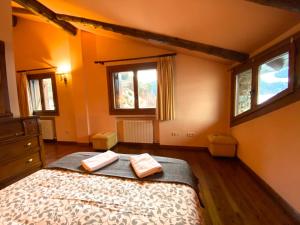 a bedroom with a bed with two towels on it at Isards, Atico rustico con chimenea en el tarter, zona Grandvalira in El Tarter