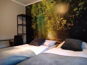 two beds in a room with a painting on the wall at Hotel Szablewski in Dymaczewo Nowe