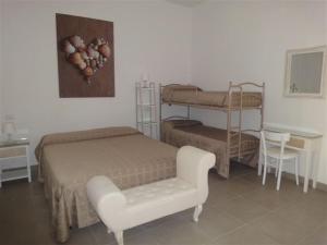 a bedroom with a bed and a chair and bunk beds at Ostello Stella Marina in Cesenatico